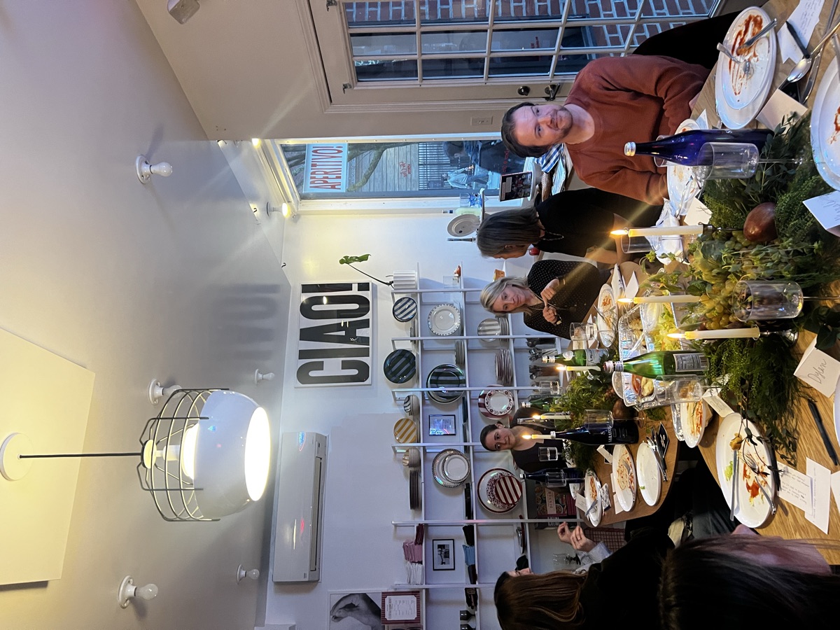 Wide view of the dining room with everyone seated and the CIAO! sign behind